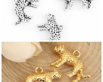 May include: A set of four silver and gold leopard charms. The charms are detailed with spots and have a loop for attaching to jewelry.