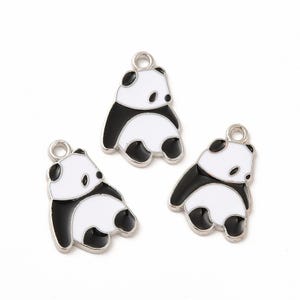 May include: Three silver charm pendants featuring black and white panda bear designs. The pandas are depicted in a standing position with their arms raised.