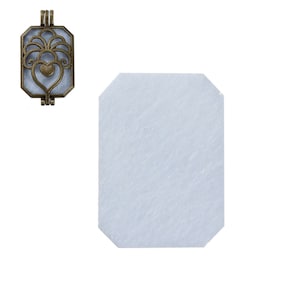 May include: A gold-toned metal locket with a filigree design and a heart in the center. The locket is open and ready to hold a charm or other small object.