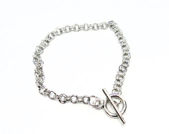 May include: A silver chain bracelet with a toggle clasp.