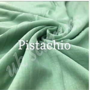 Op de afbeelding: Drie stofstalen in verschillende kleuren: een lichtbeige genaamd "Butter", een lichtgroen genaamd "Pistachio" en een lichtgrijs genaamd "Aqua Grey".
