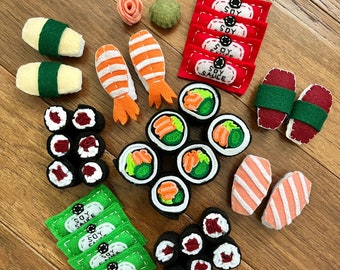 Könnte beinhalten: Ein Set Filz-Sushi-Spielzeug, bestehend aus Maki-Rollen, Nigiri und Sashimi, sowie Sojasauß-Päckchen und eine kleine Schale Wasabi.