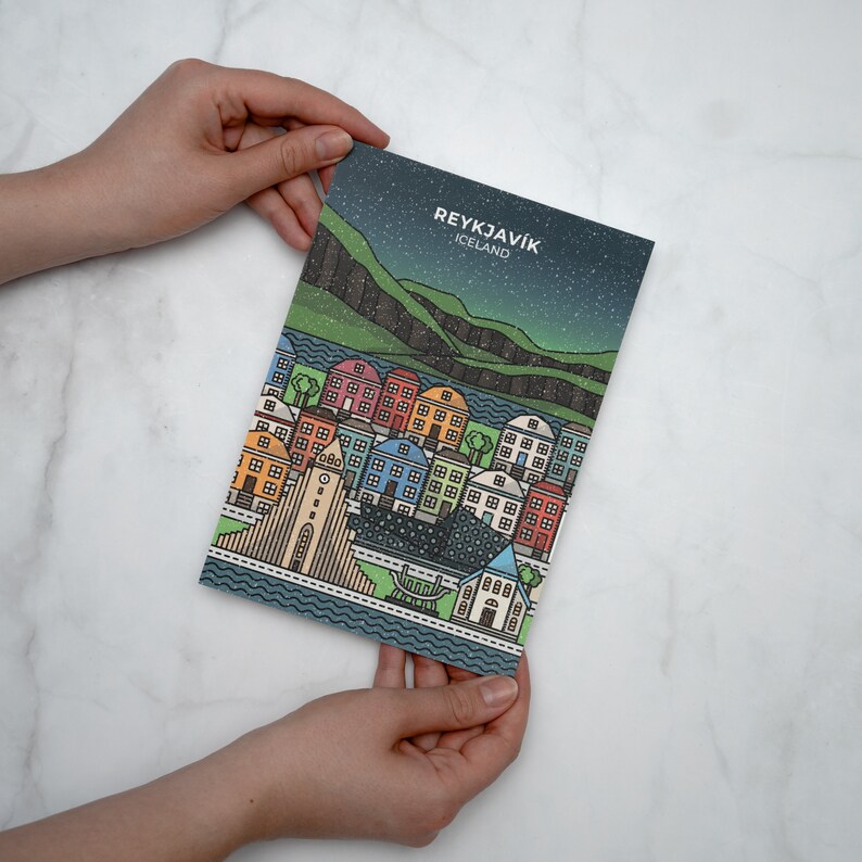 Puede incluir: Una ilustraci&oacute;n colorida de la ciudad de Reikiavik, Islandia. La ilustraci&oacute;n presenta una variedad de edificios, una iglesia y una masa de agua. El texto "REYKJAV&Iacute;K" e "ICELAND" est&aacute; impreso en la parte superior de la ilustraci&oacute;n.