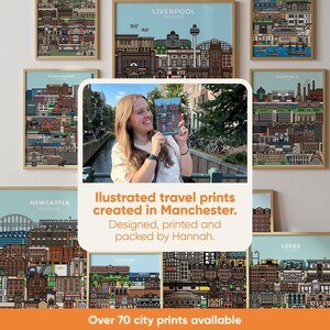 May include: A collection of framed city prints featuring detailed illustrations of various cityscapes. The prints are displayed with a light blue background and wooden frames. The text reads "Illustrated travel prints created in Manchester. Designed, printed and packed by Hannah."