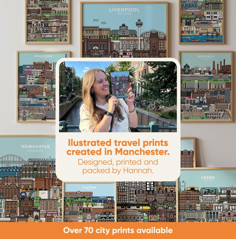 May include: A collection of framed city prints featuring detailed illustrations of various cityscapes. The prints are displayed with a light blue background and wooden frames. The text reads "Illustrated travel prints created in Manchester. Designed, printed and packed by Hannah."