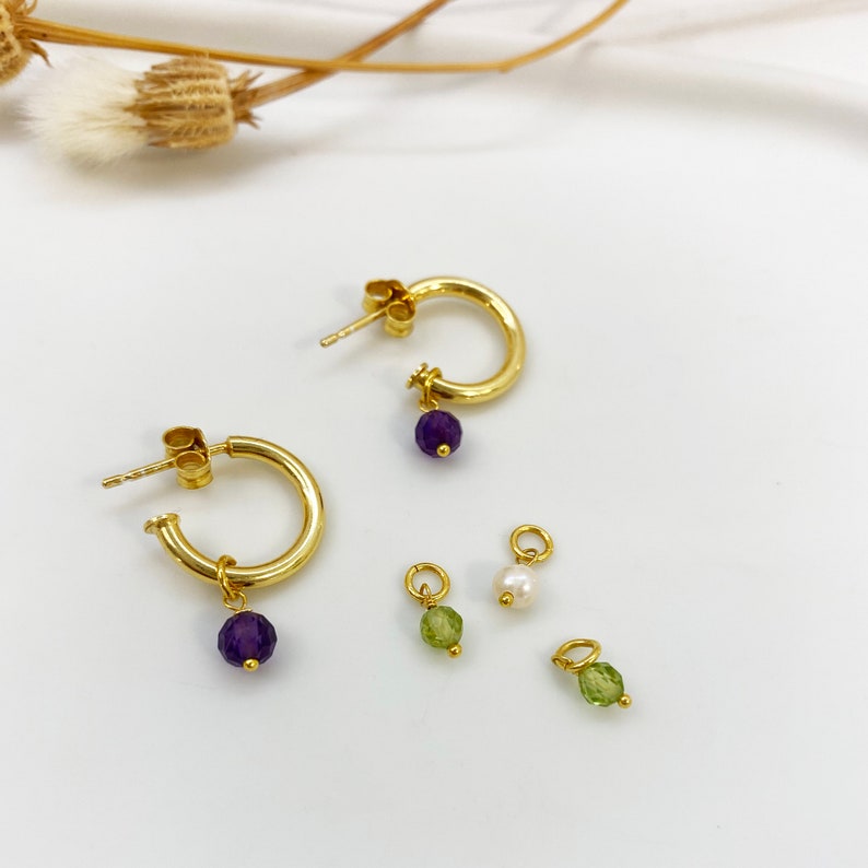 Chunky gold hoops with tiny raw stones.

Available with Amethyst or Peridot gems.

You can select the raw peridot earrings or the raw amethyst earrings.

Both small hoop earrings are a great option.
925 sterling silver and  a 24K gold finish