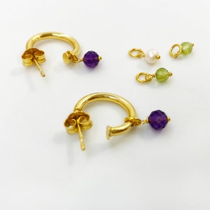 Chunky gold hoops with tiny raw stones.

Available with Amethyst or Peridot gems.

You can select the raw peridot earrings or the raw amethyst earrings.

Both small hoop earrings are a great option.
925 sterling silver and  a 24K gold finish