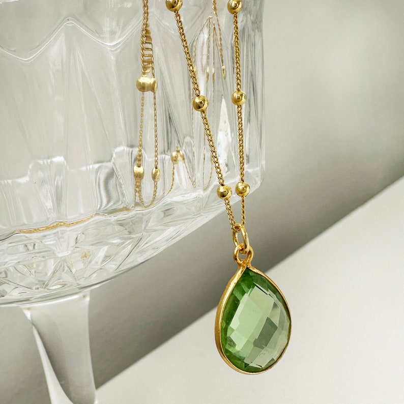 Raw Peridot Necklace in a Satellite chain. 
You will love the bright green color of the peridot pendant.
925 Sterling Silver, 24K Gold finish.
Peridot necklace is great for wearing alone or as a stacking necklace.
Peridot  promotes peace and balance.