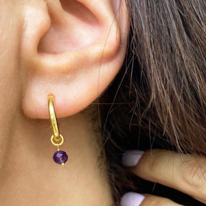 Chunky gold hoops with tiny raw stones.

Available with Amethyst or Peridot gems.

You can select the raw peridot earrings or the raw amethyst earrings.

Both small hoop earrings are a great option.
925 sterling silver and  a 24K gold finish