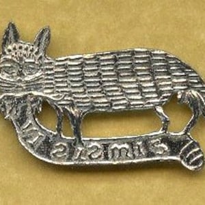 May include: A silver-coloured metal pin depicting a stylised fox. The fox has detailed fur and stands on a curved banner with the word "Times" engraved. The pin has a textured appearance.