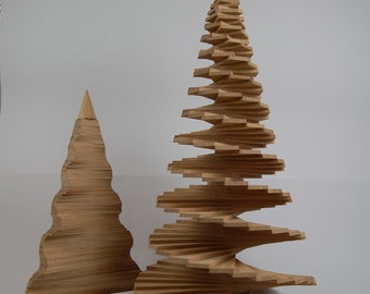 May include: Two wooden Christmas trees made of stacked, layered wood. The larger tree is a spiral design and the smaller tree is a more traditional shape.
