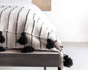 Monochromatic Opulence: Moroccan Pompom Blanket in Striking Black & White Stripes.