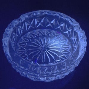 May include: A white ceramic mug with a black handle and the text "But First, Coffee" in a bold, black font. The mug is set against a neutral background, highlighting its simple design. The mug measures approximately 4 inches in height.