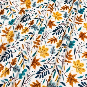 Puede incluir: Tela blanca con un estampado repetido de hojas otoñales en tonos dorados, turquesa y azul marino. El diseño incluye hojas de arce y frondas similares a helechos. La tela tiene un aspecto suave y texturizado, ideal para proyectos otoñales.