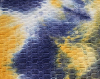 May include: A close-up of a blue and yellow tie-dye fabric with a textured, waffle-like pattern.