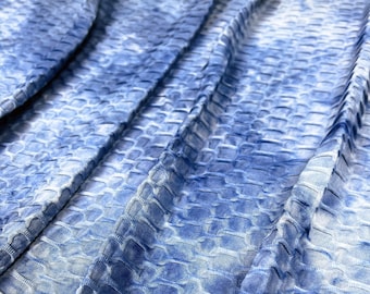May include: Blue and white textured fabric with a crinkled, wrinkled, or wavy pattern. The fabric has a subtle tie-dye effect.