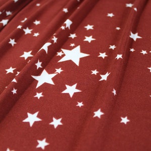 Dubbelborstad polyeten, DBP-tyg, vita spridda stjärnor mot rostbas,