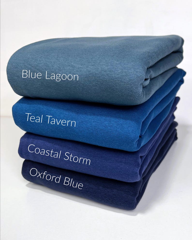May include: Four different shades of blue fabric swatches stacked on top of each other. The swatches are labeled from top to bottom: Blue Lagoon, Teal Tavern, Coastal Storm, and Oxford Blue.