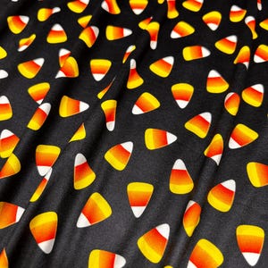 Dubbelborstad polyeten, livfullt, små godismajsmotiv på svart bas