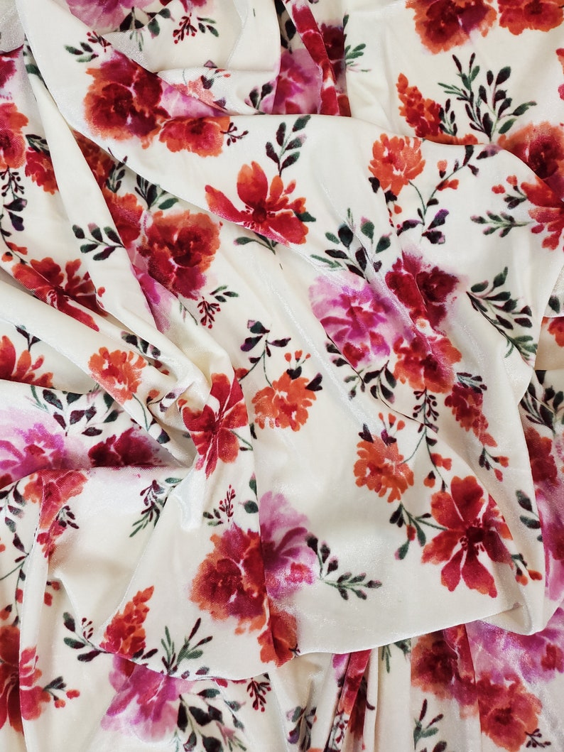 May include: White velvet fabric with a floral pattern in shades of pink, red, and orange. The flowers are stylised and have a watercolour effect.
