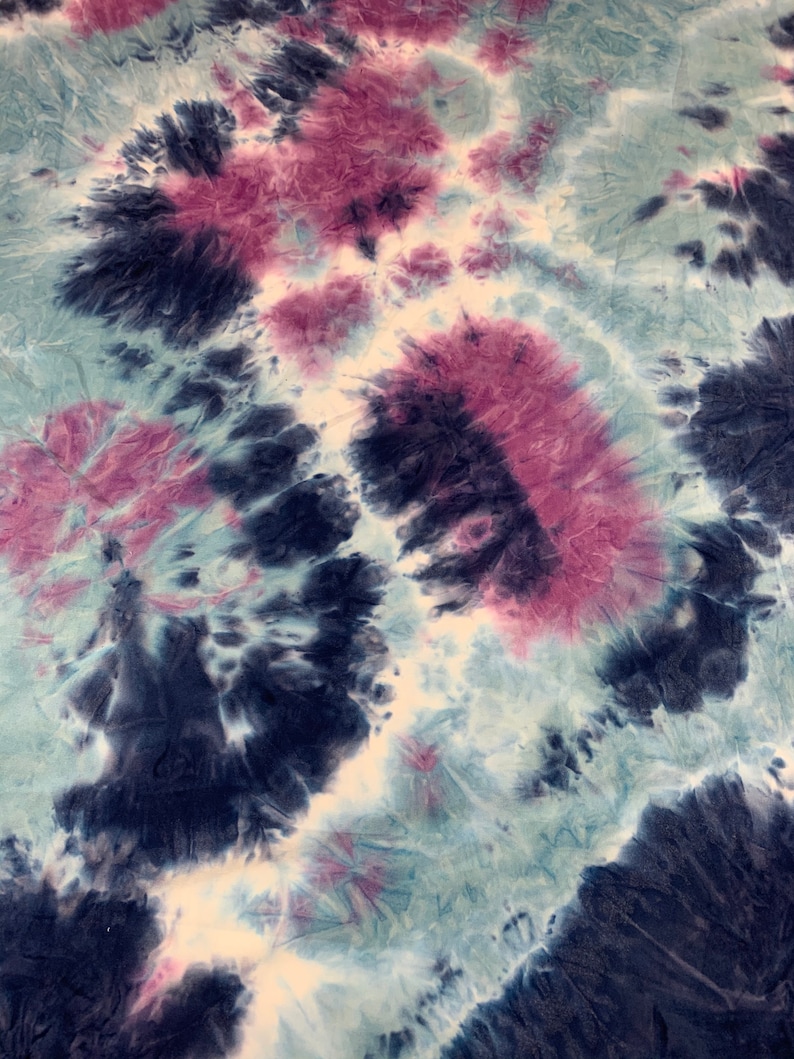 May include: Abstract tie-dye fabric with a swirling pattern of blue, white, and pink.