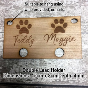 Pu&ograve; includere: Porta-guinzagli doppio in legno con due impronte di zampe e i nomi "Teddy" e "Maggie" incisi. Ha quattro fori per l'appeso e misura 15 cm per 8 cm con una profondit&agrave; di 4 mm.