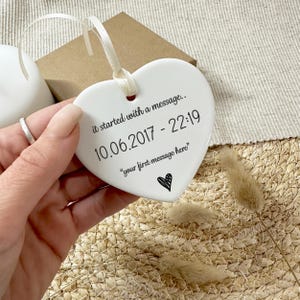 May include: White ceramic heart ornament with the text "it started with a message... 10.06.2017 - 22:19 "your first message here""