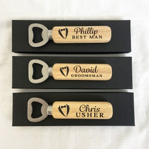 May include: Three wooden bottle openers with a silver bottle opener head. Each opener has a tuxedo graphic and personalized text. The top opener says "Phillip Best Man", the middle opener says "David Groomsman", and the bottom opener says "Chris Usher".