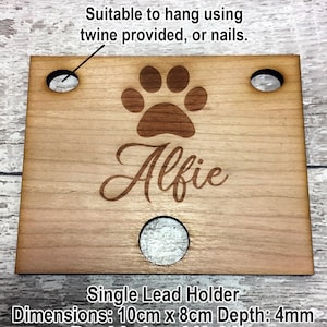 Pu&ograve; includere: Porta-guinzaglio per cani in legno con un'impronta di zampa e il nome "Alfie" inciso. Il porta-guinzaglio ha tre fori per appenderlo. Dimensioni: 10 cm x 8 cm, Profondit&agrave;: 4 mm.