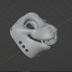 May include: A light gray, 3D-rendered mask of a feline head. The mask has large eye openings, a prominent nose, and a smiling mouth. Three circular holes are on the left side of the mask. The mask is set against a dark gray grid background.