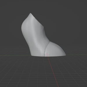 May include: A light gray, curved object, possibly a shoe heel, is depicted against a dark gray background. The object has a smooth surface and a rounded shape, with a seam visible near the base. The image is set against a grid.