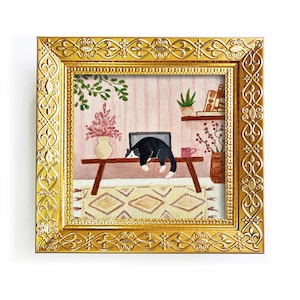 May include: A square painting in an ornate gold frame depicting a black and white cat lying on a wooden bench. The scene includes a pink vase with flowers, a small potted plant, a shelf with books, a red mug, and a patterned rug on the floor.