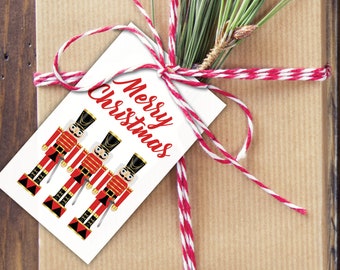 May include: White gift tag with three red and black toy soldier illustrations and the text "Merry Christmas" in red cursive.