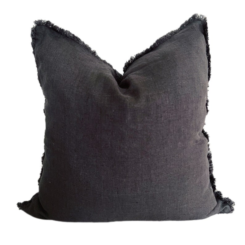 May include: A black linen pillow with a frayed edge. The pillow is square and has a soft, textured surface.