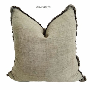 May include: Olive green throw pillow with a fringed edge.