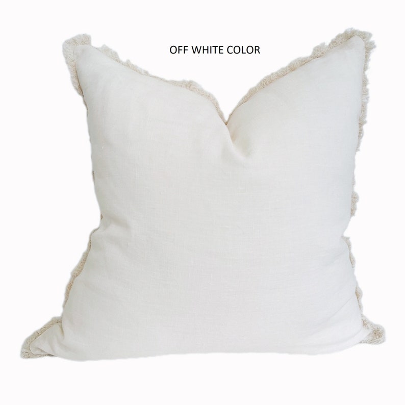 May include: Off-white throw pillow with a fringed edge.