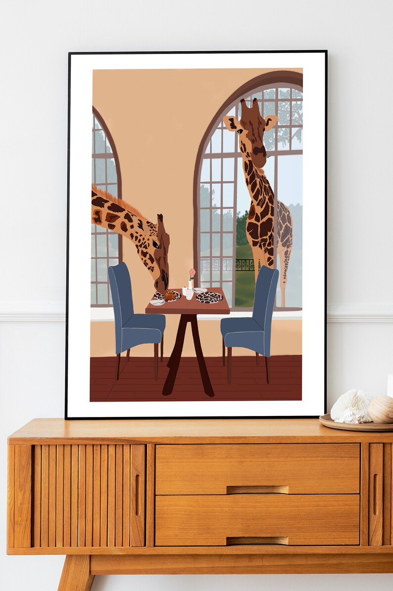 May include: Two giraffes are eating at a table with two blue chairs. The giraffes are looking at the viewer. The table is set with a plate, a cup, and a pink flower. The scene is set in a room with a large window.
