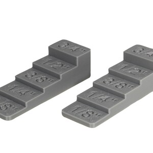 May include: Two gray plastic stepped blocks with markings for 1/8, 1/4, 3/8, 1/2, and 3/4 inch.