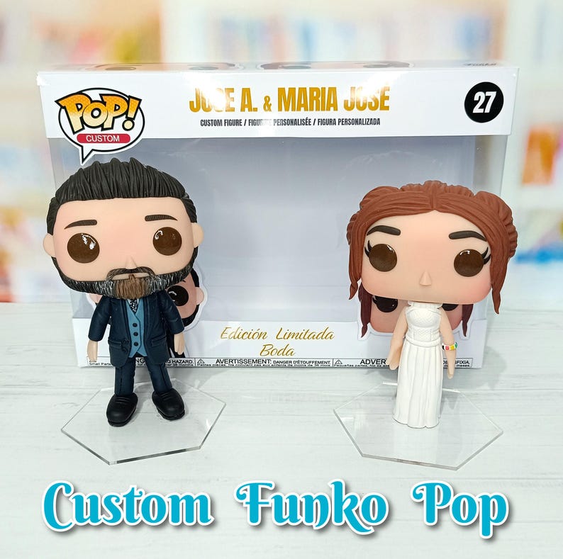 May include: Custom Funko Pop figures of a bride and groom. The bride is wearing a white dress and the groom is wearing a blue suit. The figures are on clear plastic stands. The box says "Edici&oacute;n Limitada Boda" which means "Limited Edition Wedding" in Spanish.