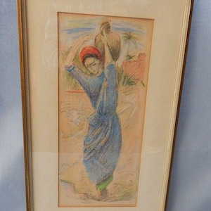 Puede incluir: Obra de arte pastel enmarcada que representa a una persona con un vestido azul que lleva una jarra de agua sobre la cabeza. La obra presenta un tocado rojo y detalles verdes, sobre un fondo de un paisaje desértico con palmeras.