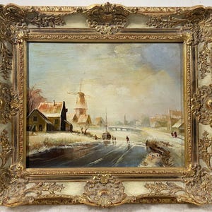 以下が含まれることがあります： オランダの村の冬の風景を描いた油絵の額縁入り作品。風車、凍った運河、スケートをする人々が描かれている。空は薄い青色で、ピンクと黄色の色合いが混ざっている。