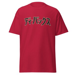 May include: Red t-shirt with the text "デイ・バッグス" in black and gold lettering.