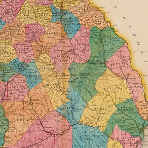 May include: A vintage map of Georgia, USA, showing the counties and their names. The map is colour-coded with different shades of pink, yellow, green, and blue. The map is dated 1860.