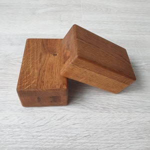 Peut inclure: Deux blocs de bois, l'un empilé sur l'autre, tous deux en bois brun clair avec un motif de grain naturel.