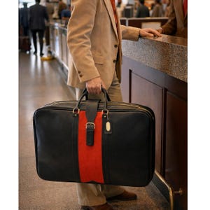 May include: A white ceramic mug with a black handle and the text "But First, Coffee" in a bold, black font. The mug is set against a blurred background, suggesting a cozy setting.