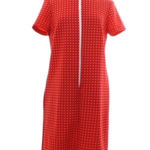 May include: A knee-length red dress featuring a repeating pattern of small white dots. The garment has short sleeves, a round neckline, and a full-length vertical white zipper running down the center front from the neck to the hemline.
