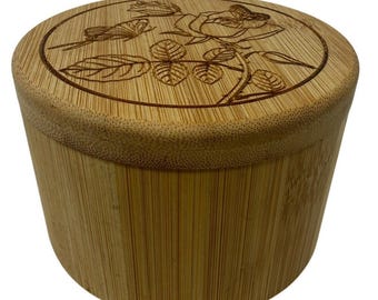 Salero de madera de bambú con tapa giratoria, cuchara y diseño floral de mariposa.