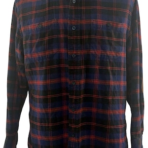 May include: A long-sleeved flannel shirt in a classic plaid pattern. The shirt features a combination of navy blue, black, and red colors. It has a button-down front, a collar, and two chest pockets. The shirt is displayed on a mannequin.