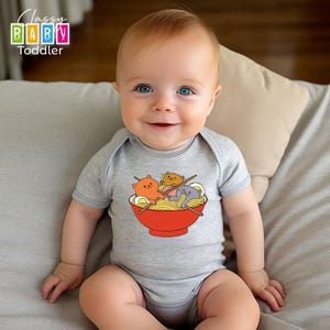 a baby sitting on a bed wearing a bodysuit