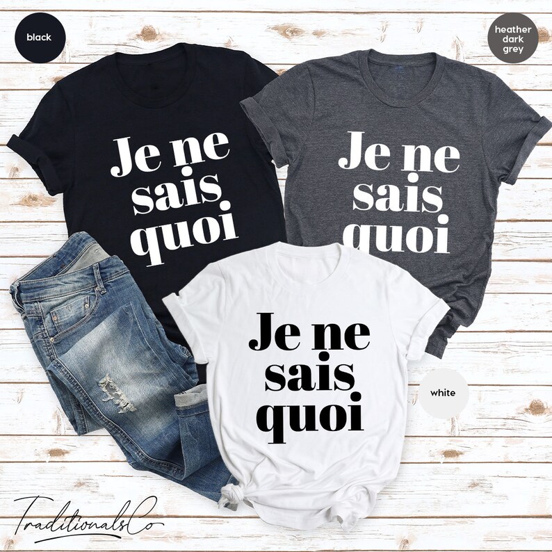 May include: Three t-shirts with the French phrase "Je ne sais quoi" printed in black on them. The shirts are in black, heather dark grey, and white.